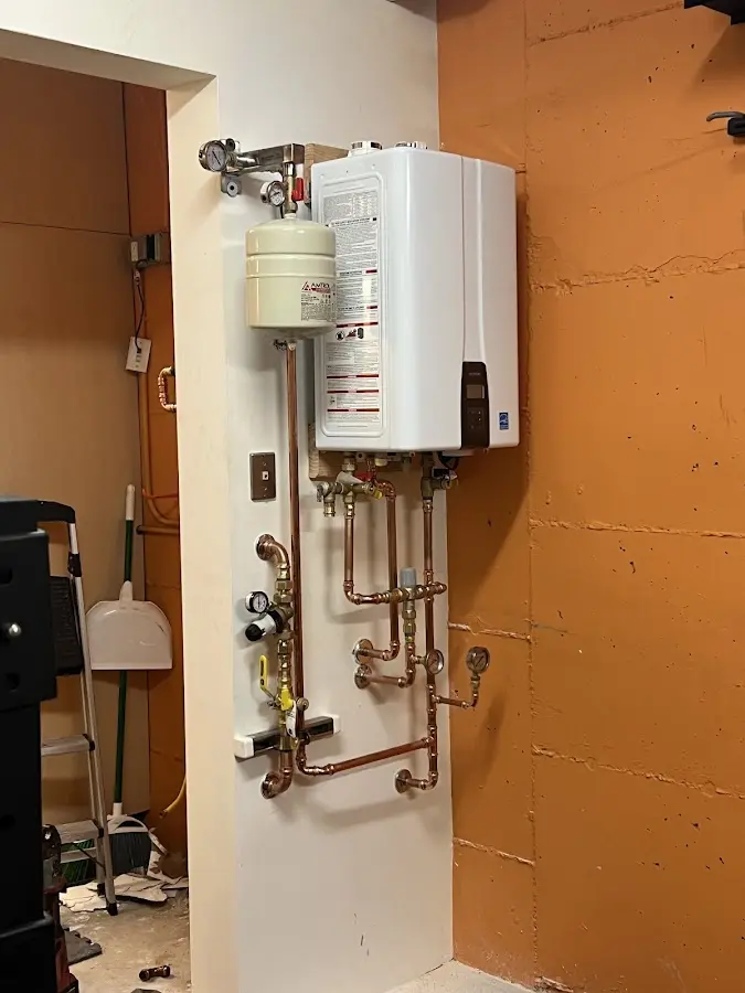 Plumbing technician inspecting water heater connections in Willowbrook